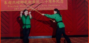 Vance Young (left) and Ting Poo performing "Double Sabres versus Spear" weapon sparring form at the 20th Anniversary Celebration, May, 2002.